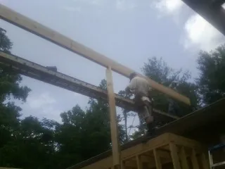 Carpenter setting a ridge beam over a new addition frame — Ice Dam Removal by Roofing Brothers in Mount Blanchard