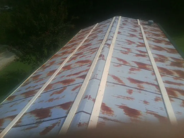 Rusted metal roof panels with new wood purlins before replacement — Storm Damage Roof Repair in Mount Blanchard by Roofing Brothers